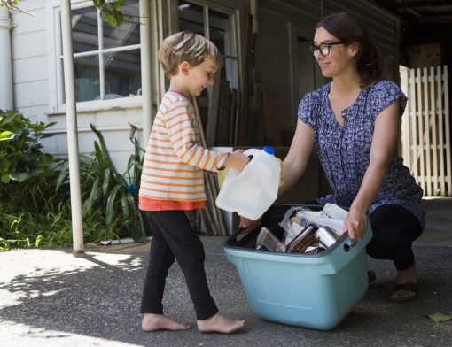 Mãe e filho juntando garrafas plásticas para reciclagem
