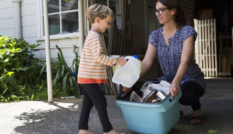 Mãe e filho juntando garrafas plásticas para reciclagem